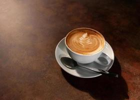 Cup of hot latte art in afternoon light on wooden table photo